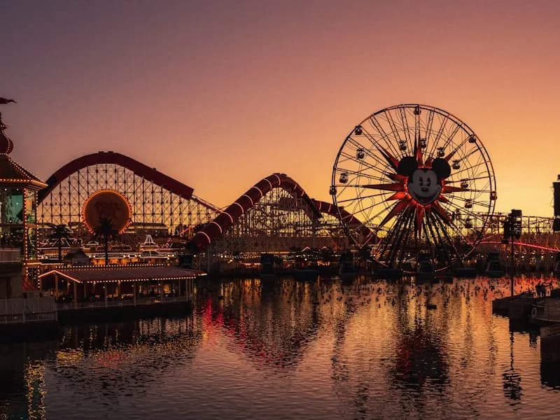 Pixar Pier wheel, roller coaster, and waterfront at dusk
